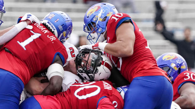 Nov 11, 2023; Lawrence, Kansas, USA; Texas Tech Red Raiders quarterback Behren Morton (2) runs the ball and nearly loses his helmet as Kansas Jayhawks linebacker Jayson Gilliom (10) makes the tackle during the first half at David Booth Kansas Memorial Stadium. Mandatory Credit: Denny Medley-USA TODAY Sports  